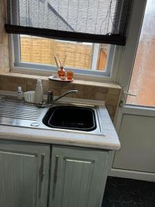 a kitchen with a sink and a window at The White House - Cheerful 3 Bedroom home in Wigan - Ince - sleeps 7 - parking - Work space - Great motorway links in Ince-in-Makerfield