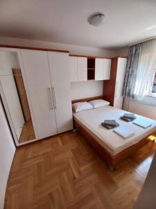 Schlafzimmer mit einem Bett mit weißen Schränken und Holzböden in der Unterkunft Apartman Kajzerica in Zagreb
