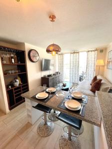 cocina y sala de estar con mesa y sillas en Departamento en Avenida Del Mar, en La Serena