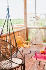a porch with two chairs and a swing at Corazon Mexicano Holbox in Holbox Island