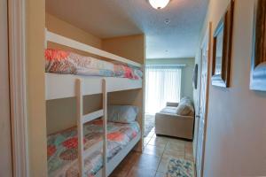 een slaapkamer met 2 stapelbedden en een bank bij Gulf Island Condominium 722 in Navarre