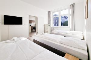 um quarto branco com três camas e uma televisão em RAJ Living - 1 Room Monteur Apartments - 25 Min Messe DUS em Duisburg
