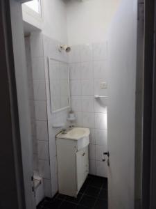 a white bathroom with a sink and a mirror at Aires de mar 2 in San Clemente del Tuyú