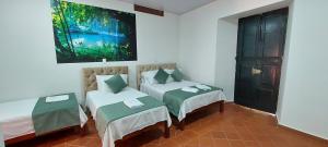 Zimmer mit 2 Betten und Wandgemälde in der Unterkunft HOTEL BOUTIQUE SIMACOTA in Simacota
