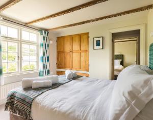 a bedroom with a large white bed and a window at Crow's Nest in Port Isaac