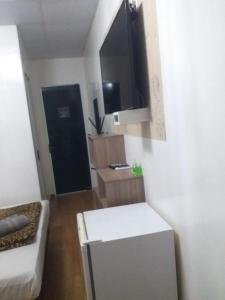 a small living room with a white couch and a black door at Hotel Pousada Carazinho in Caràzinho