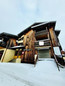 un edificio con nieve en el suelo delante de él en Grand Studio aux pieds des pistes sans vis à vis, en Les Gets