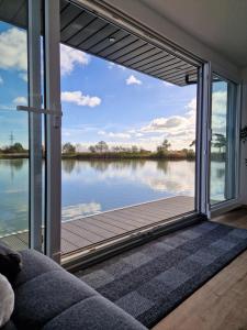 a living room with a view of the water at Hausboot auf dem Wangermeer in Wangerland