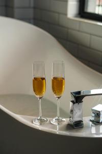 two glasses of wine sitting on a bath tub at Boutique Hotel Kviria in Tʼelavi