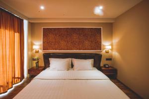 泰拉維的住宿－Boutique Hotel Kviria，一间卧室配有一张带2个床头柜的大型白色床