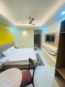 een slaapkamer met een bed en een plafondventilator bij Royal Beach International in Puri