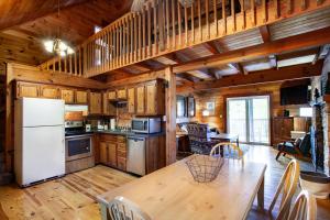 une cuisine avec une table et un réfrigérateur blanc dans l'établissement Pet-friendly Rustic Cabin with Game Room and Deck, à Pigeon Forge