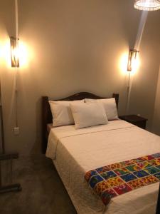 a bedroom with a bed and two lights on the wall at Pousada Vila Lua Bela in Pitimbu