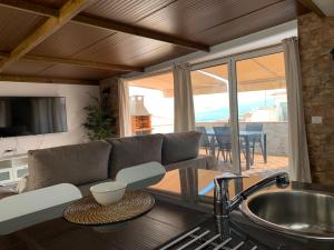 Una cocina y una sala de estar con un sofá y una mesa. en Ático Pablo 5, a cinco minutos del Puerto de la Cruz, en Los Realejos