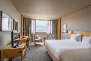 a hotel room with a large bed and a television at The Lince Azores in Ponta Delgada