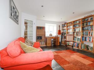 a living room with a red couch and book shelves at The Roundhouse in Bodmin