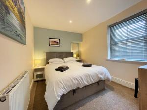 Un dormitorio con una cama grande y una ventana en Arthurs Cottage -Charming Courtyard Cottage in the heart of Kendal, The Lake District en Kendal