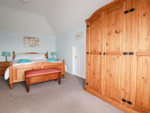 a bedroom with a bed and a large wooden cabinet at The Roundhouse in Bodmin