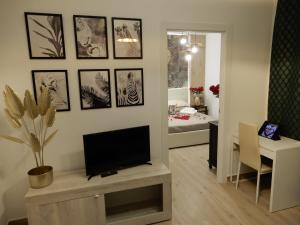uma sala de estar com uma televisão de ecrã plano na parede em Caserta Royale Suite em Caserta