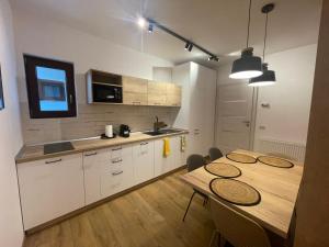 a kitchen with a table and some chairs in it at Pine Tree Residence in Sinaia
