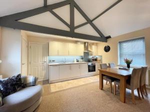 a living room with a table and a kitchen at Arthurs Cottage -Charming Courtyard Cottage in the heart of Kendal, The Lake District in Kendal