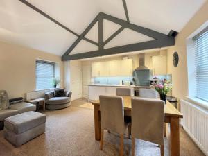 uma sala de estar com uma mesa e uma cozinha em Arthurs Cottage -Charming Courtyard Cottage in the heart of Kendal, The Lake District em Kendal