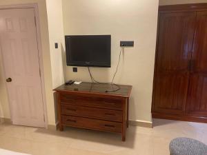 a television on a wooden dresser in a room at 1 BHK Luxury Beachside Homestay in South Goa in Betalbatim