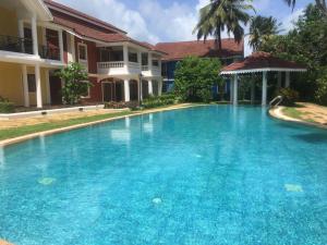 a large blue swimming pool in front of a house at 1 BHK Luxury Beachside Homestay in South Goa in Betalbatim