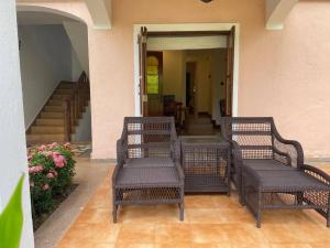 three wicker chairs sitting on a porch with stairs at 1 BHK Luxury Beachside Homestay in South Goa in Betalbatim