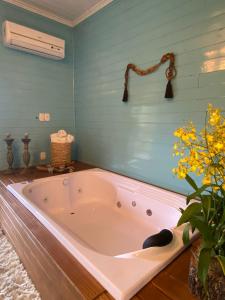 uma banheira na casa de banho com paredes azuis em Reserva da Collina em Gramado