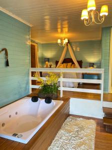 uma banheira num quarto com uma cama em Reserva da Collina em Gramado
