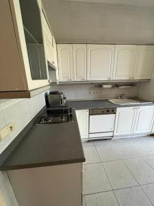 a kitchen with white cabinets and a black counter top at Bel appartement avec vue sur parc - Tour Japonaise in Brussels