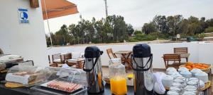 uma mesa com comida e sumo de laranja num pátio em Paracas Guest House em Paracas