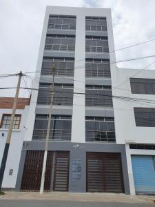 un edificio blanco alto con puertas abiertas en Apartamentos "APPART D'ELIETTE" en Trujillo
