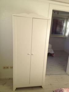 a white cabinet in a room with a bedroom at Schöne 2-Zimmer Wohnung in Geesthacht in Geesthacht