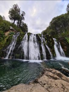 una cascata in mezzo a un corpo d'acqua di La casita del bosque a San Martín de los Andes