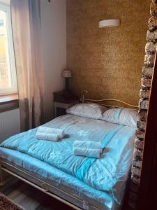 uma cama com lençóis e almofadas azuis num quarto em Olszynowy Dwór em Zwola Poduchowna