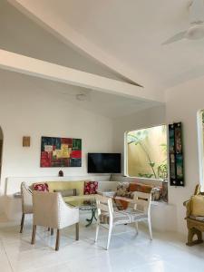 a living room with a couch and a table and chairs at Villa del Mare / Centro da Ilha in Ilhabela