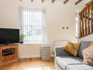 een woonkamer met een bank en een flatscreen-tv bij 1 Greenswood Court in Brixham