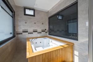 un bagno con vasca e ampia finestra di Exclusive Villas Kalkan a Çayköy