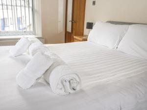 een stapel handdoeken bovenop een bed bij 1 Greenswood Court in Brixham