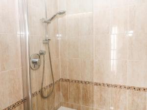 een douche met een douchekop in de badkamer bij 1 Greenswood Court in Brixham