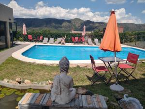 a statue of a woman sitting next to a swimming pool at Complejo Namaste in San Antonio de Arredondo