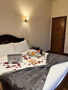 un letto con delle rose sopra con un portatile sopra di Hyde Park House Hotel ad Alessandria d'Egitto