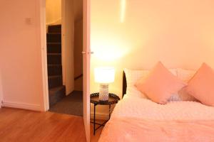 a bedroom with a bed and a lamp on a table at Cozy Family Stay with Free Parking and WiFi in Knowsthorpe