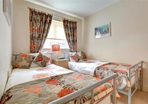 a bedroom with two beds and a window at The Lookout in Saundersfoot