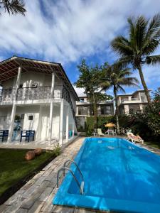 eine Villa mit einem Pool vor einem Haus in der Unterkunft Casa da Praia Juquehy JQY in Juquei