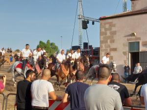 a group of people watching a group of men on horses at Arcamyrtus in Alghero