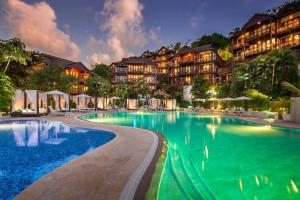a resort swimming pool with a hotel in the background at Zoetry Marigot Bay - All Inclusive in Marigot Bay