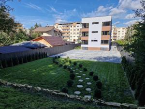 un jardín con un seto frente a un edificio en Royal Maison Apartments en Cluj-Napoca